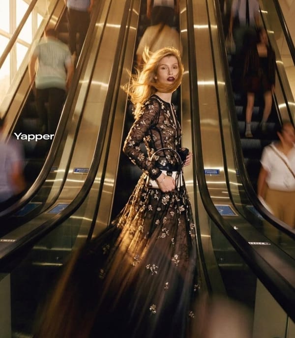 Ultra-realistic cinematic fashion photograph of a stylish blonde woman standing confidently bet…