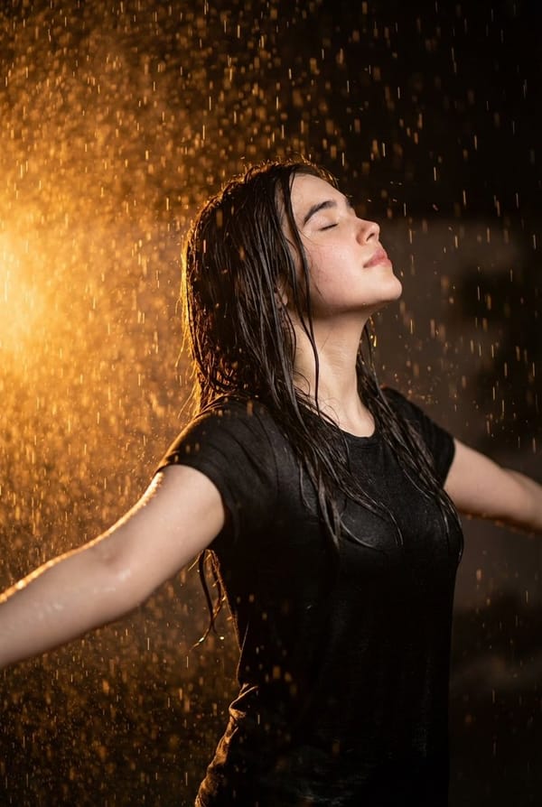 Ultra realistic cinematic portrait of a 32-year-old young woman standing in heavy rain at night…