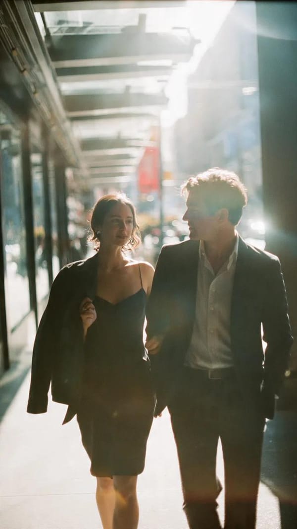 A cinematic candid medium shot portrait of a man and a woman walking side by side along a bright ur… prompt example