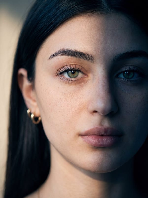 Ultra-realistic close-up portrait of a young woman with fair skin and subtle freckles, green ey…