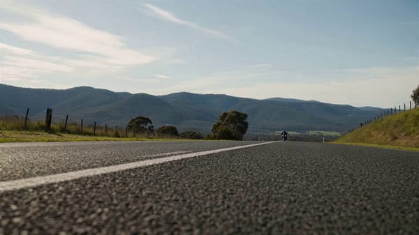 SHOT 01: Ultra-low tracking shot inches above asphalt, a sportbike already at extreme speed bla…