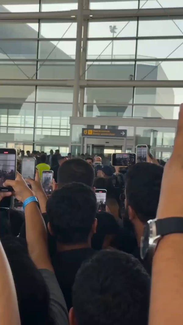 Style: Ultra-realistic mass celebrity arrival scene. Single continuous shot. Handheld camera fr…
