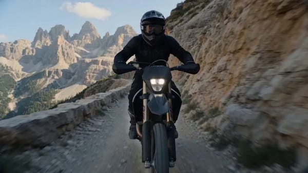 Hyper-realistic cinematic 15s action sequence. A rider accelerates along a narrow cliff trail a…