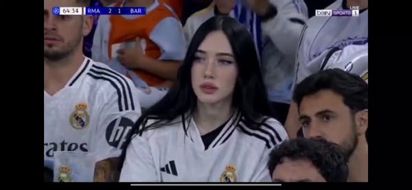 A high-definition, realistic broadcast shot of a young woman sitting in a crowded football stadium… prompt example