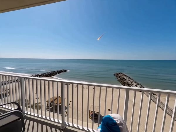 A shaky, panicked handheld recording from the balcony of a sea-facing hotel during the day. The…