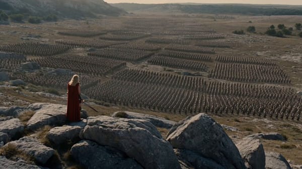 Cinematic fantasy sequence: A powerful female warrior stands on jagged rocks overlooking a chao…