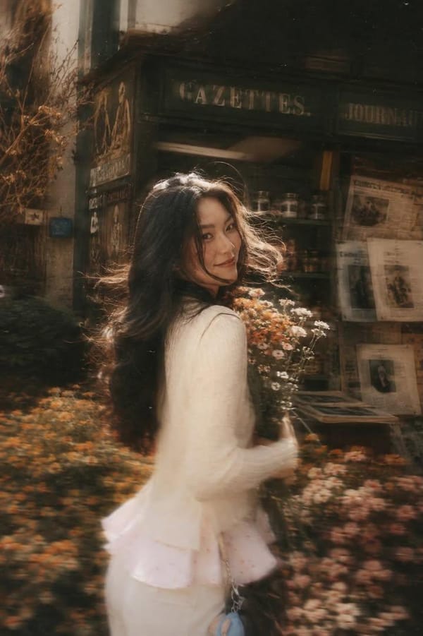 A beautiful young woman with long dark flowing hair holding a bouquet of soft pink roses, turni…