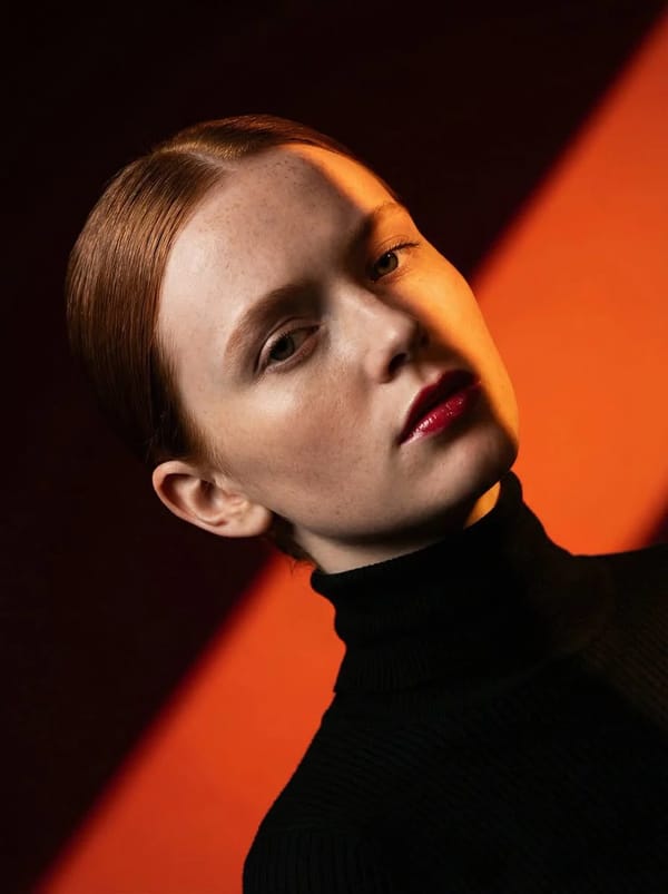 Ultra-high-fashion editorial beauty portrait of a fair-skinned female model with sleek center-p…