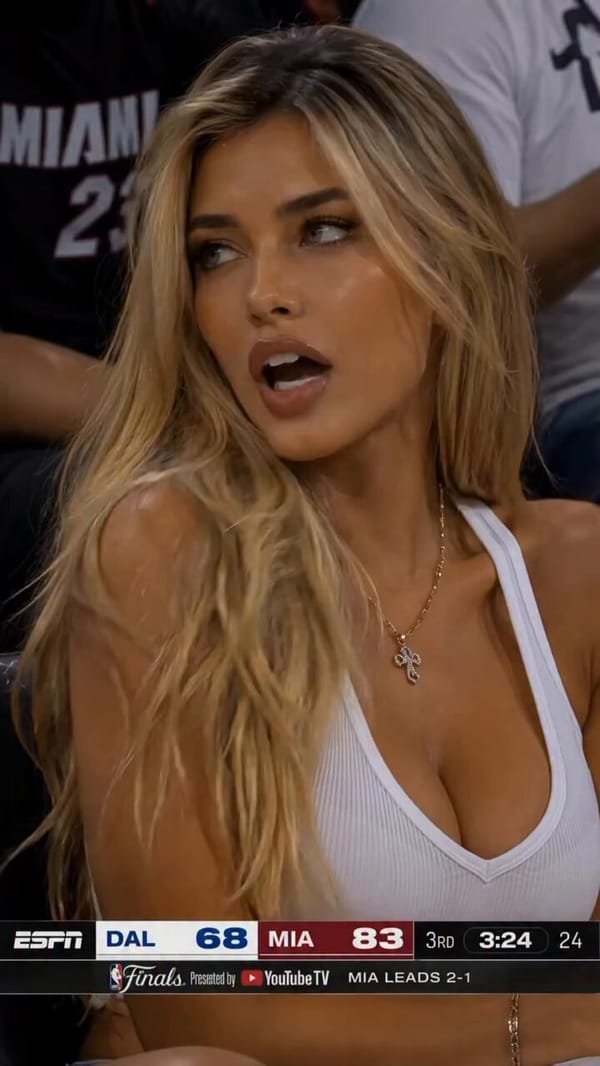 Hyper-realistic NBA courtside camera shot of a stunning brunette woman sitting front row during a M… prompt example