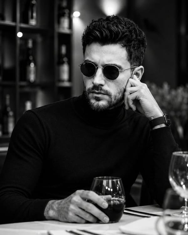 Ultra-realistic black-and-white cinematic portrait of a handsome man seated in an upscale luxur…