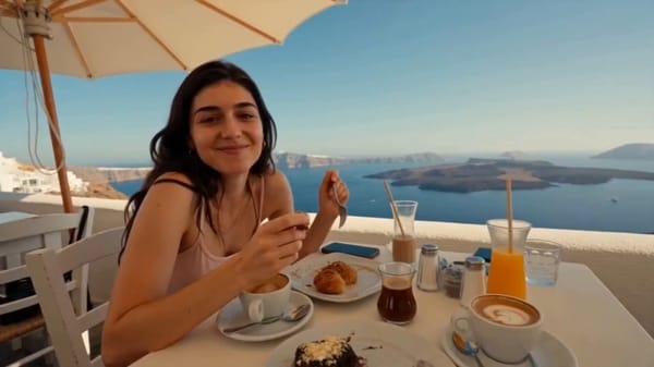 Young female travel vlogger exploring Santorini, Greece, beautiful with long wavy sunlit hair,…