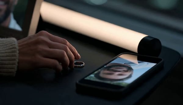 15 second cinematic emotional modern-day scene, set clearly in 2026. A woman in her 30s sits al…