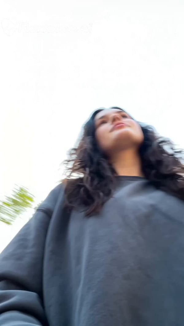 0:00–0:01 Low-angle handheld selfie in front of Tokyo Tower, slightly tilted horizon, she adjus…