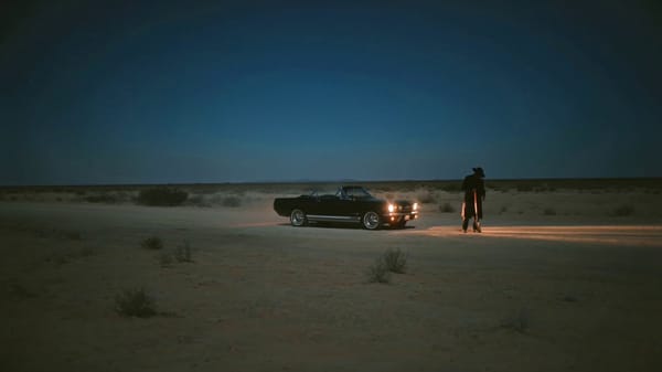 Cinematic gritty neo-noir night scene in the desert, man digging a deep hole in front of his pa…