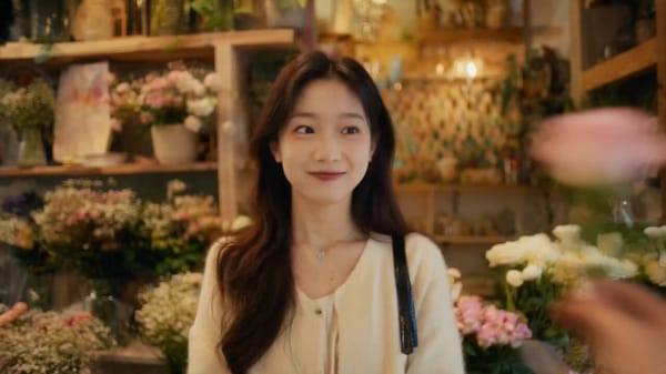 镜头跟随花从画面右侧递入,女孩接花后轻轻扬起花束。场景2 @图像2英格兰街 头,微凉天气,街景自然。男士接过一枝康乃馨,微笑点头,说: prompt example