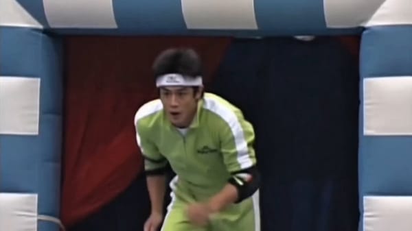 0-3s: [Wide handheld tracking shot from the front-left] A determined young Japanese male contestant… prompt example