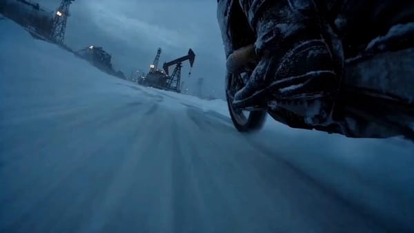 "A dangerous motorcycle ice racer with frost-covered black racing gear, mirrored helmet visor,…