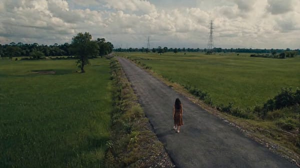 Scene & Mood: A quiet uncanny rural road scene. The open countryside from image2 feels real and…