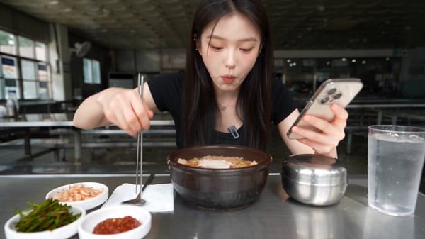 A single woman eats Korean pork-and-rice soup alone in the restaurant from Image , following th…
