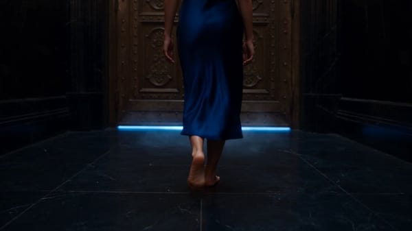 Outfit: A luxurious deep navy-blue satin midi dress, fitted but elegant, with thin shoulder str…