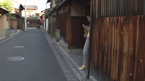 5–11s: Enters a small neighborhood bakery/konbini-style shop, notices a fresh melon pan and say…