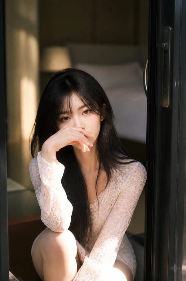 A beautiful Asian woman with long, flowing dark hair sits gracefully in the threshold of an ope…