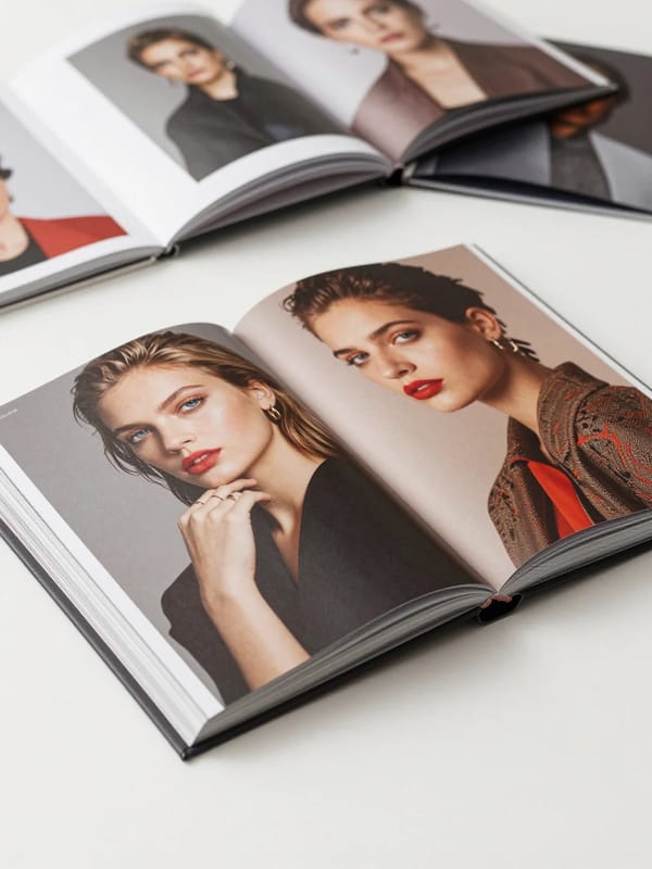 Luxury photorealistic coffee table book, open to two pages, showcasing an artistic composition…