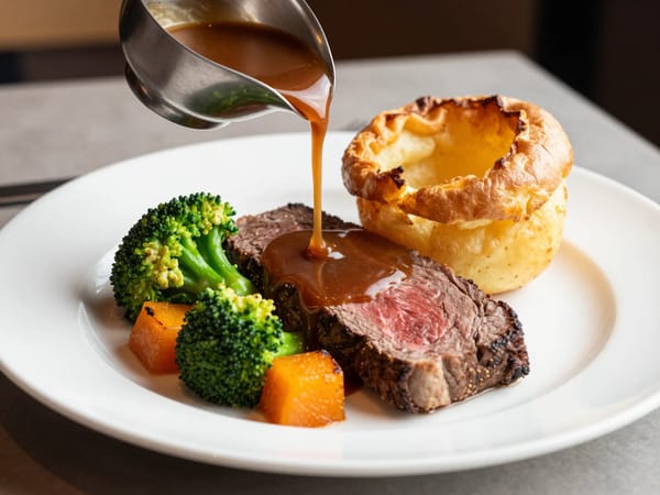 Professional food photography of a gourmet roast dinner served on a white ceramic plate. Juicy…