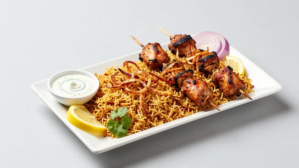 Professional food photography of a delicious seekh kebab platter served on a clean white rectan…