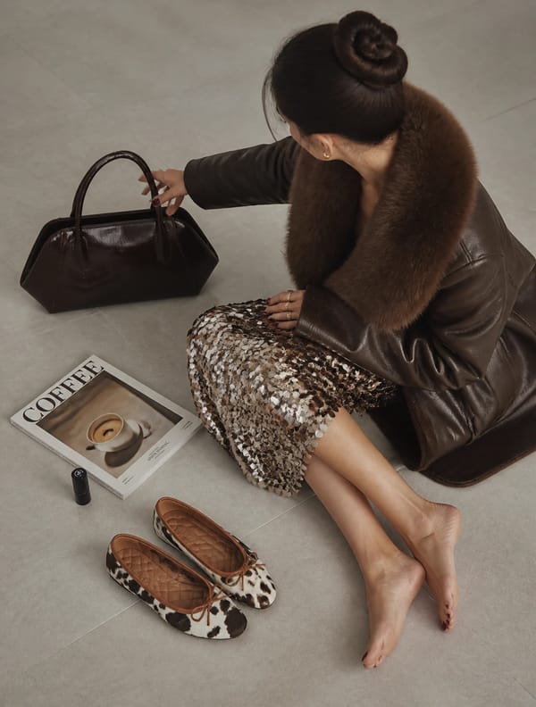 A high-angle shot captures a woman, appearing to be a young adult, with fair skin, seated on a…