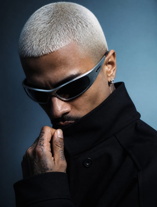 A realistic photograph of a man posed in a high-fashion editorial studio portrait, his head til…